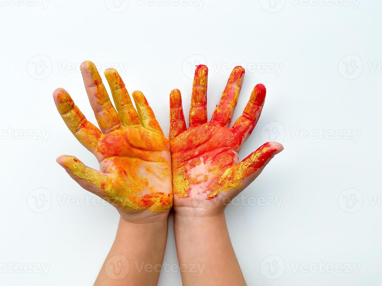 Childrens hands painted with yellow and red paint on white background. photo