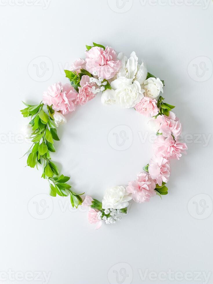 Round frame of pink and white carnations, leaves photo