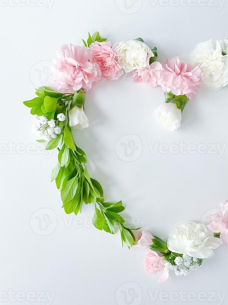 Frame in form of heart from pink, white carnations photo