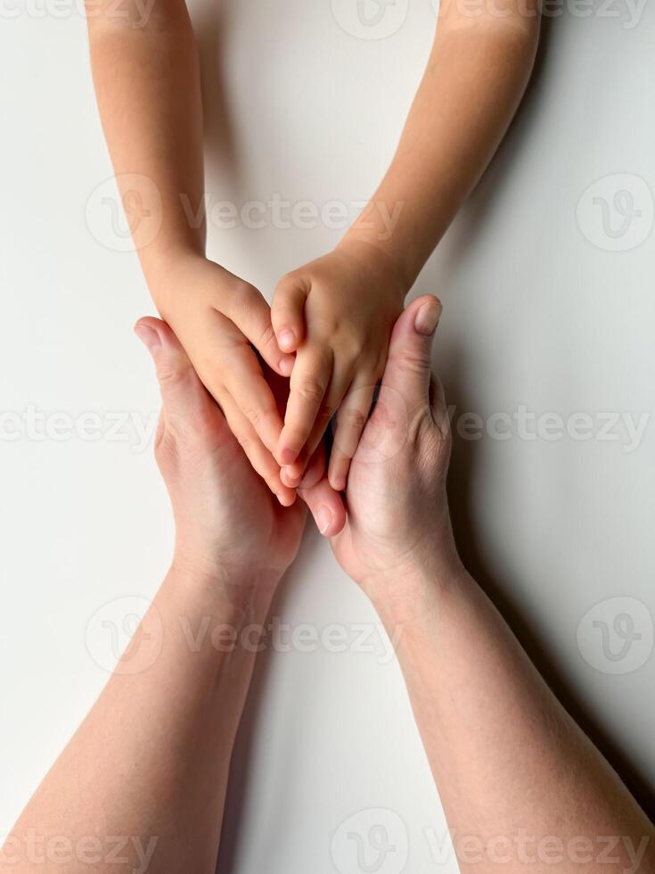 Mothers hands holding childs hands on white background. photo