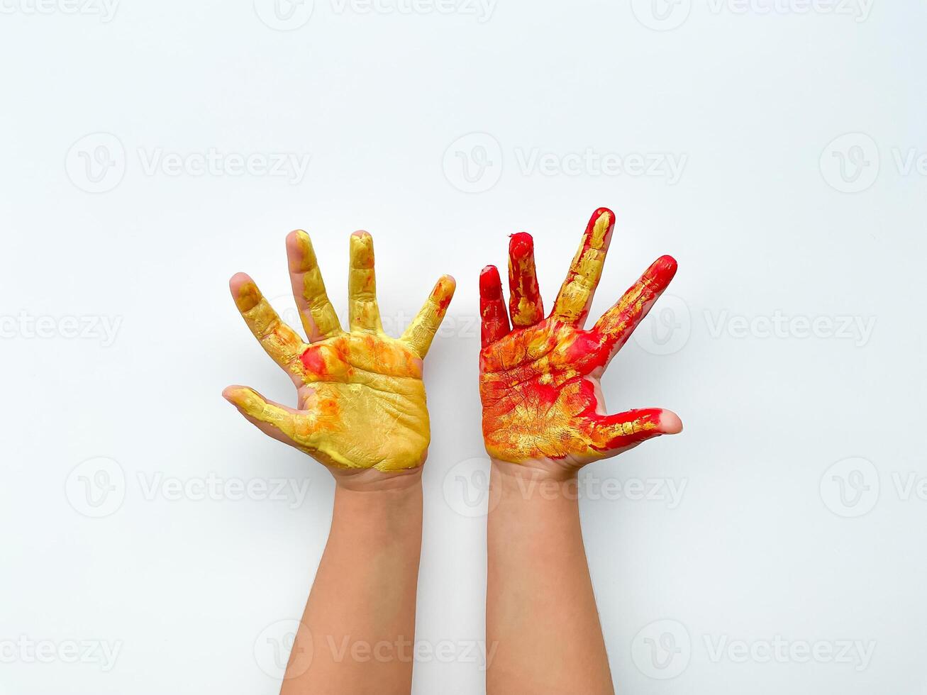 Childrens hands painted with yellow and red paint on white background. photo