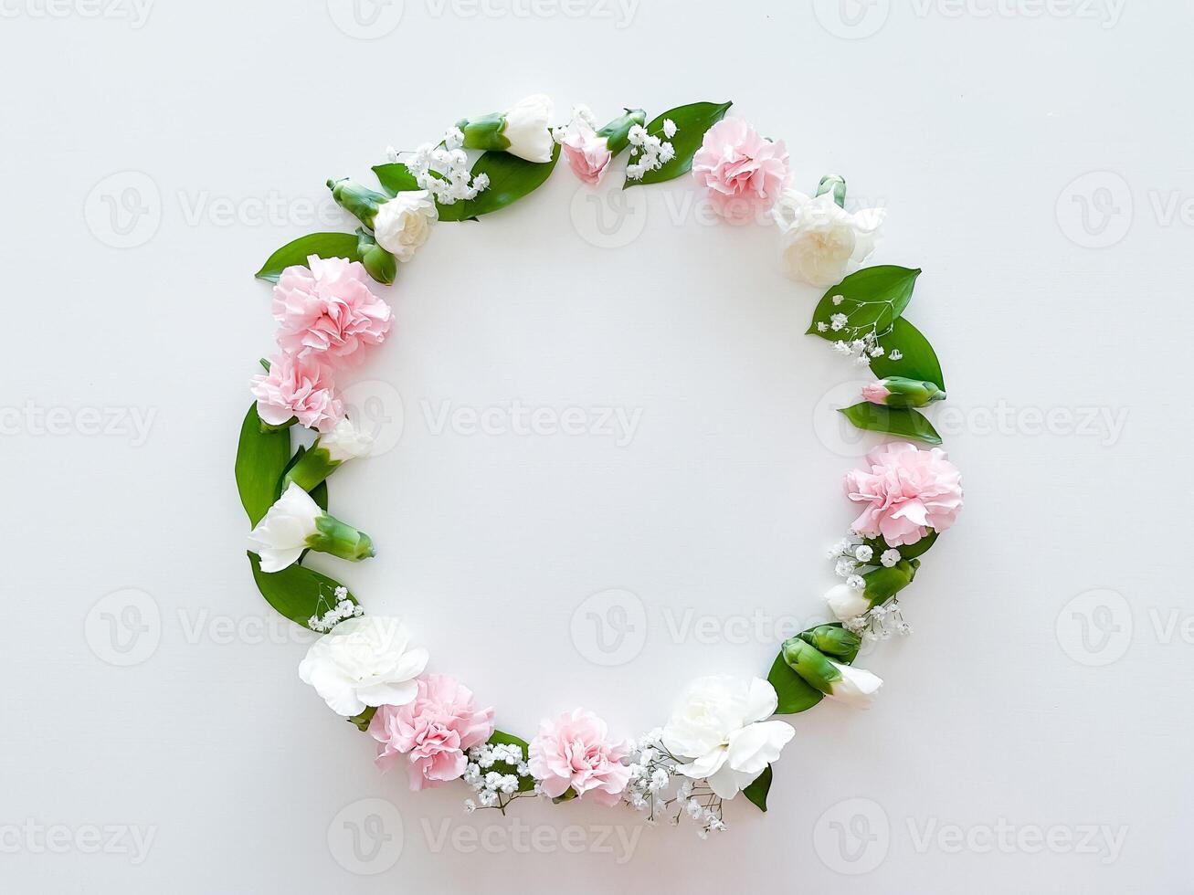 Round frame of pink and white carnations, leaves photo