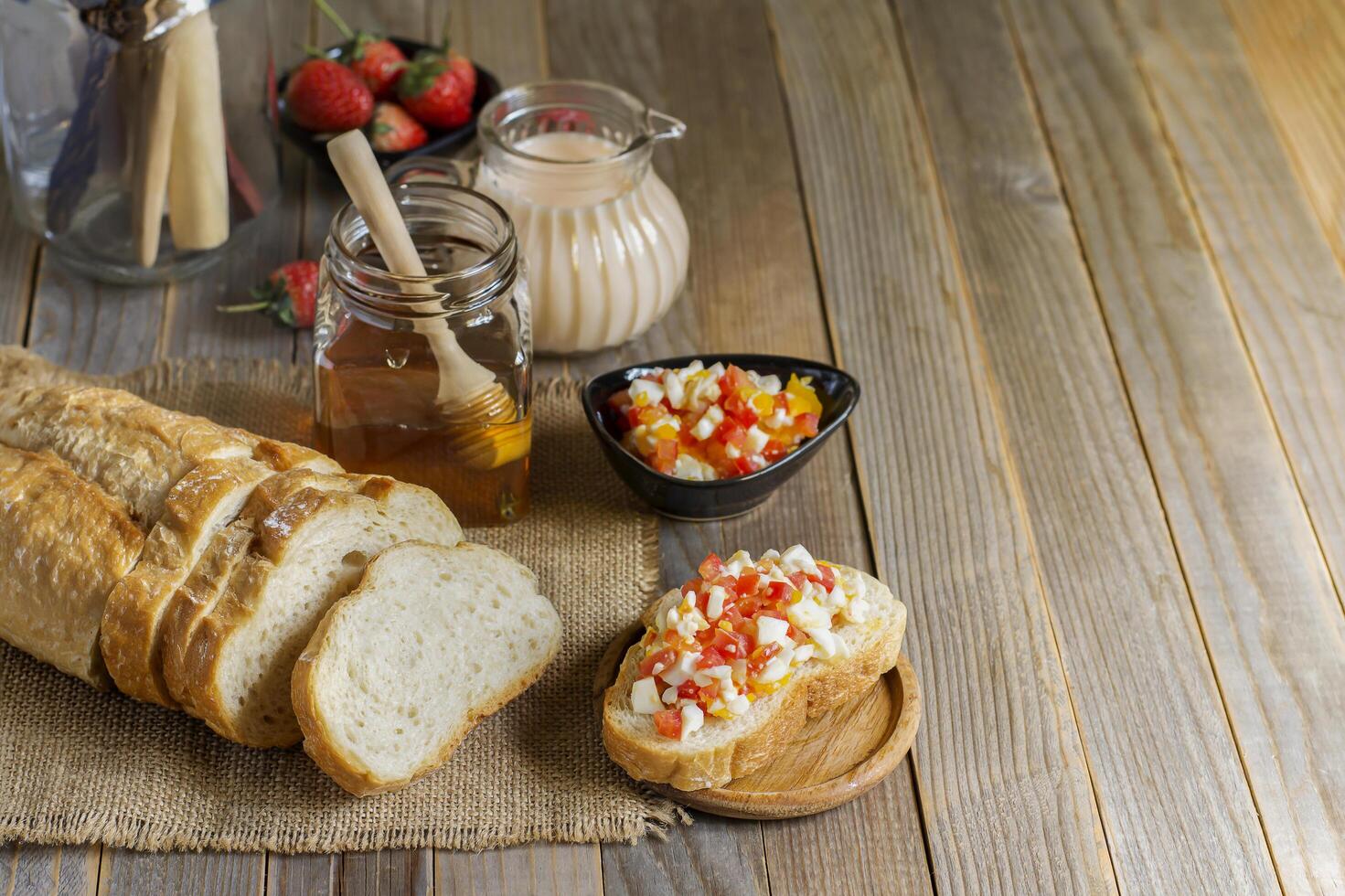 Breakfast bread with strawberry milk And eggs laid on the old wooden floor with copy space photo