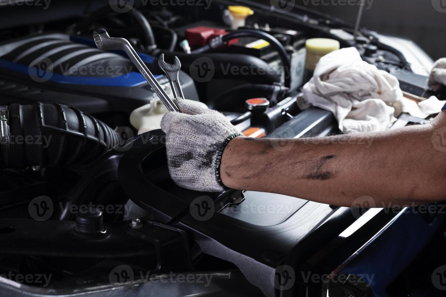 Car maintenance, vehicles, and automation technology, services Technician in hand uses wrench to repair broken car engine parts. and support car insurance services photo