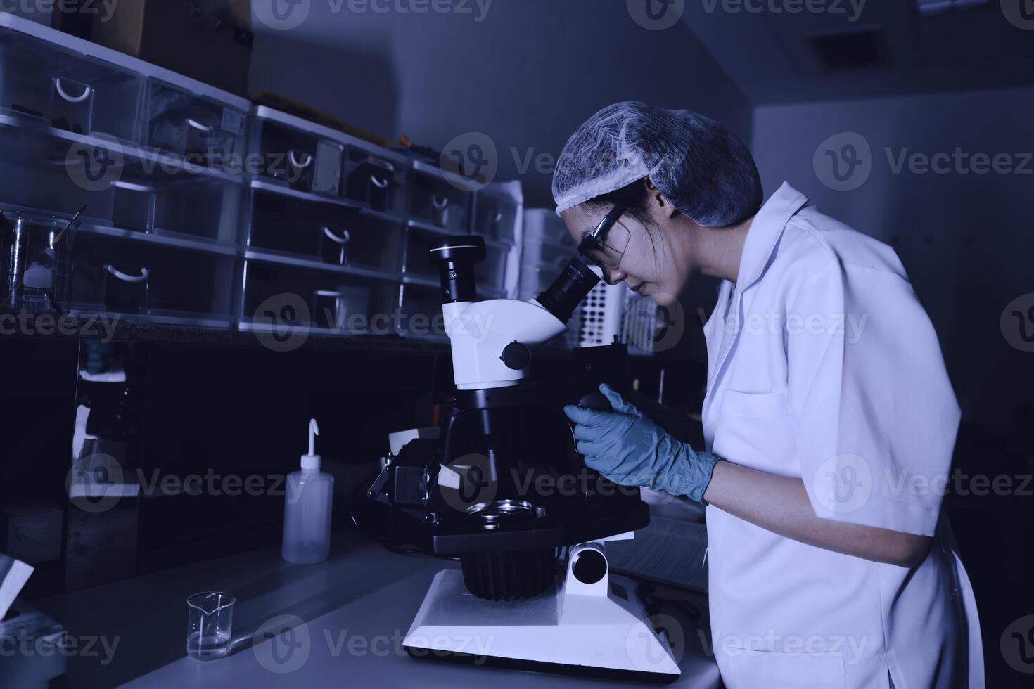 asiático científico trabajando en el laboratorio,investigadores son investigación a encontrar el resultados de el experimento, doctores son pruebas sangres a evitar y destruir nuevo son de el coronavirus mediante microscopía. foto