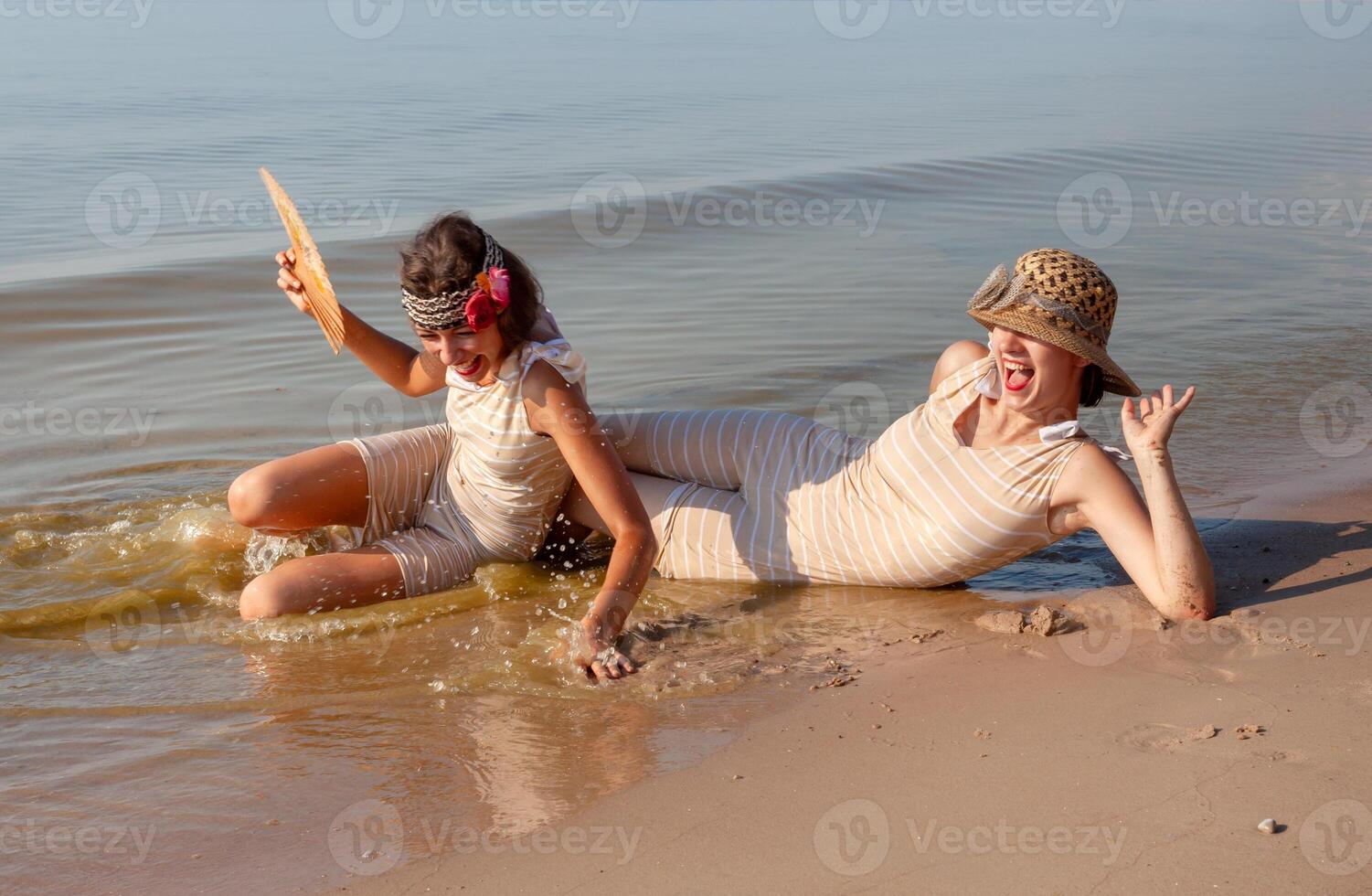 dos joven mujer en retro trajes de baño por el mar foto