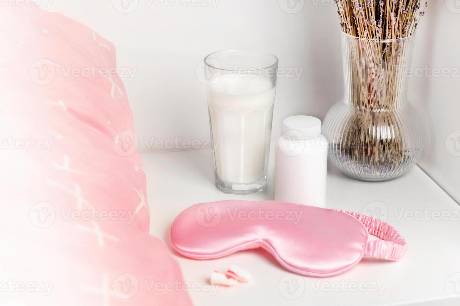 Bedside table with a silk sleep mask, earplugs and lavender and warm milk for a good night's sleep and sleeping pill mock up. All conditions for good deep sleep. Help for falling asleep photo