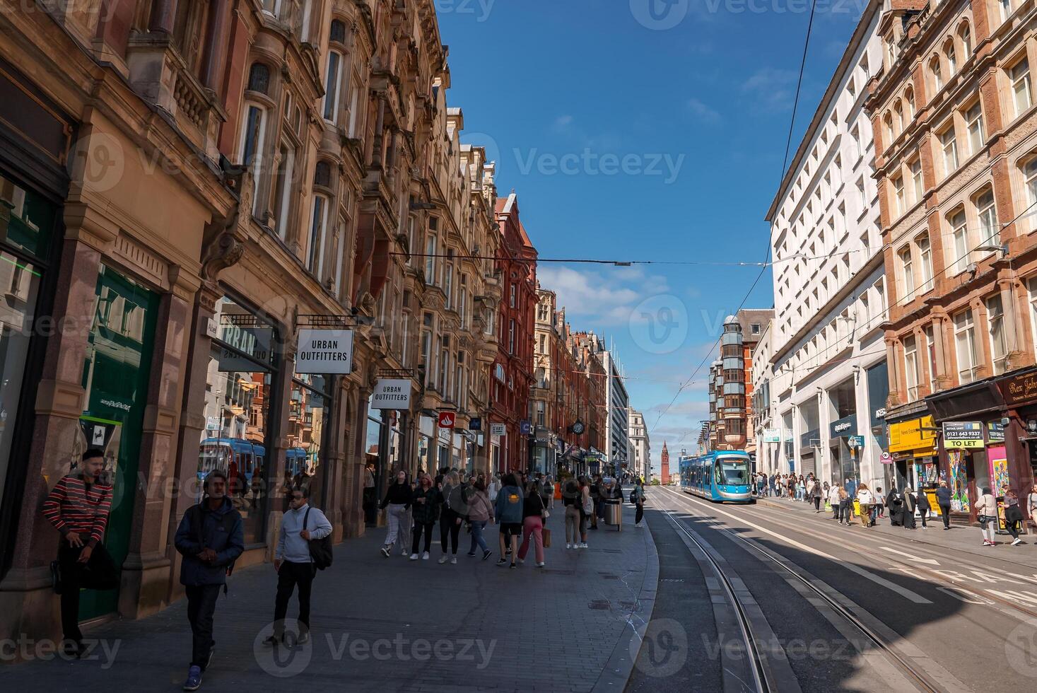 Bustling Birmingham Street with Historic Buildings and Modern Tram photo