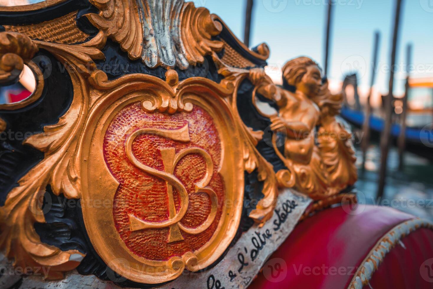 Close-up of ornate red and gold gondola in Venice, Italy with no passengers photo