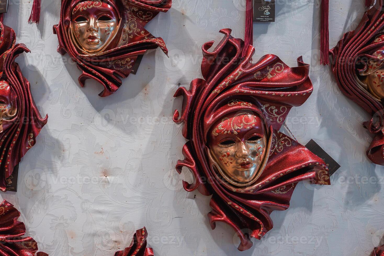 Collection of Red Venetian Masks Displayed in Dimly Lit Interior in Venice, Italy photo