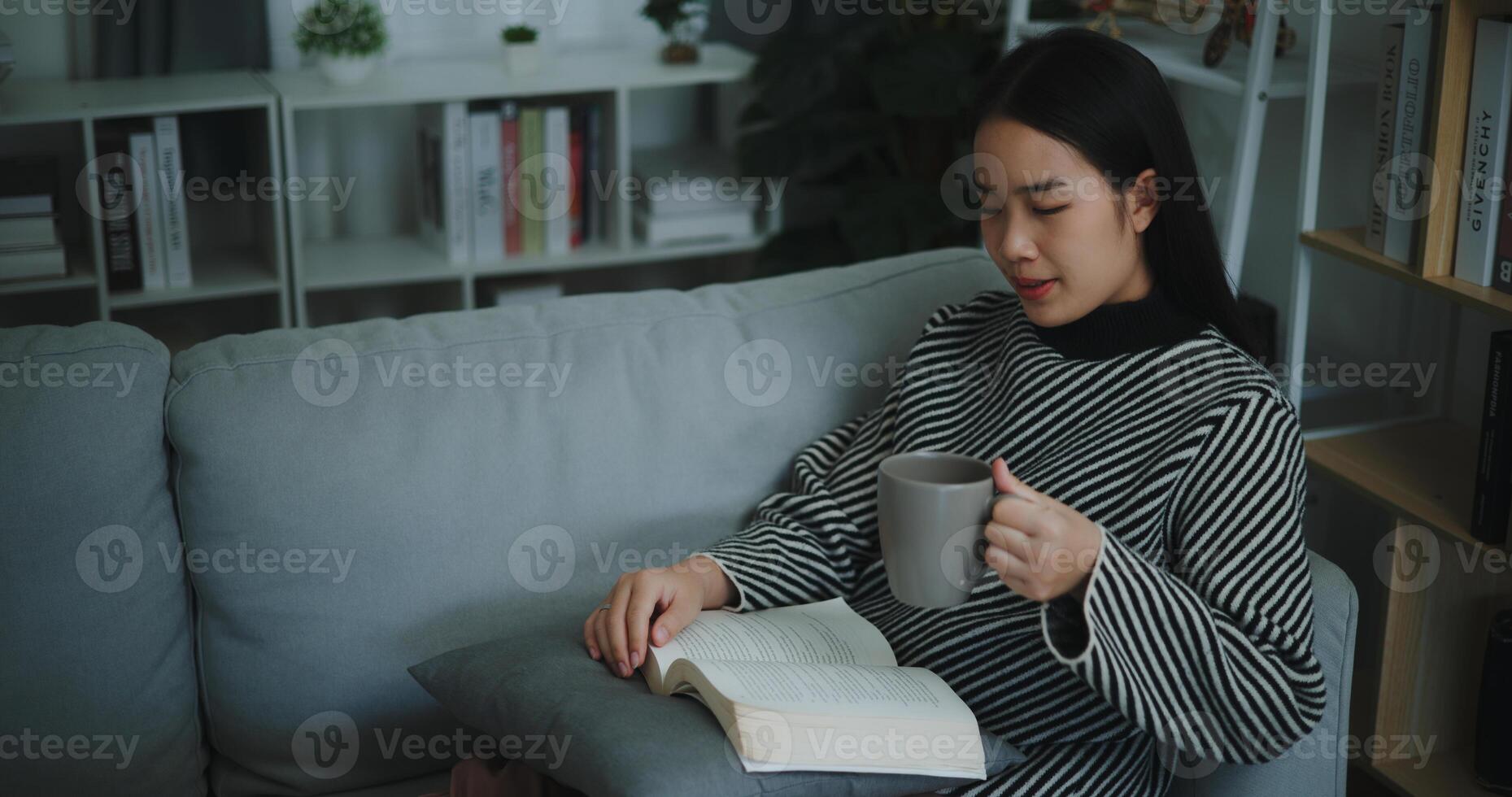 retrato de contento joven asiático mujer Bebiendo Mañana café o té y leyendo en vivo habitación a hogar en fin de semana. ocio y estilo de vida, gratis hora foto