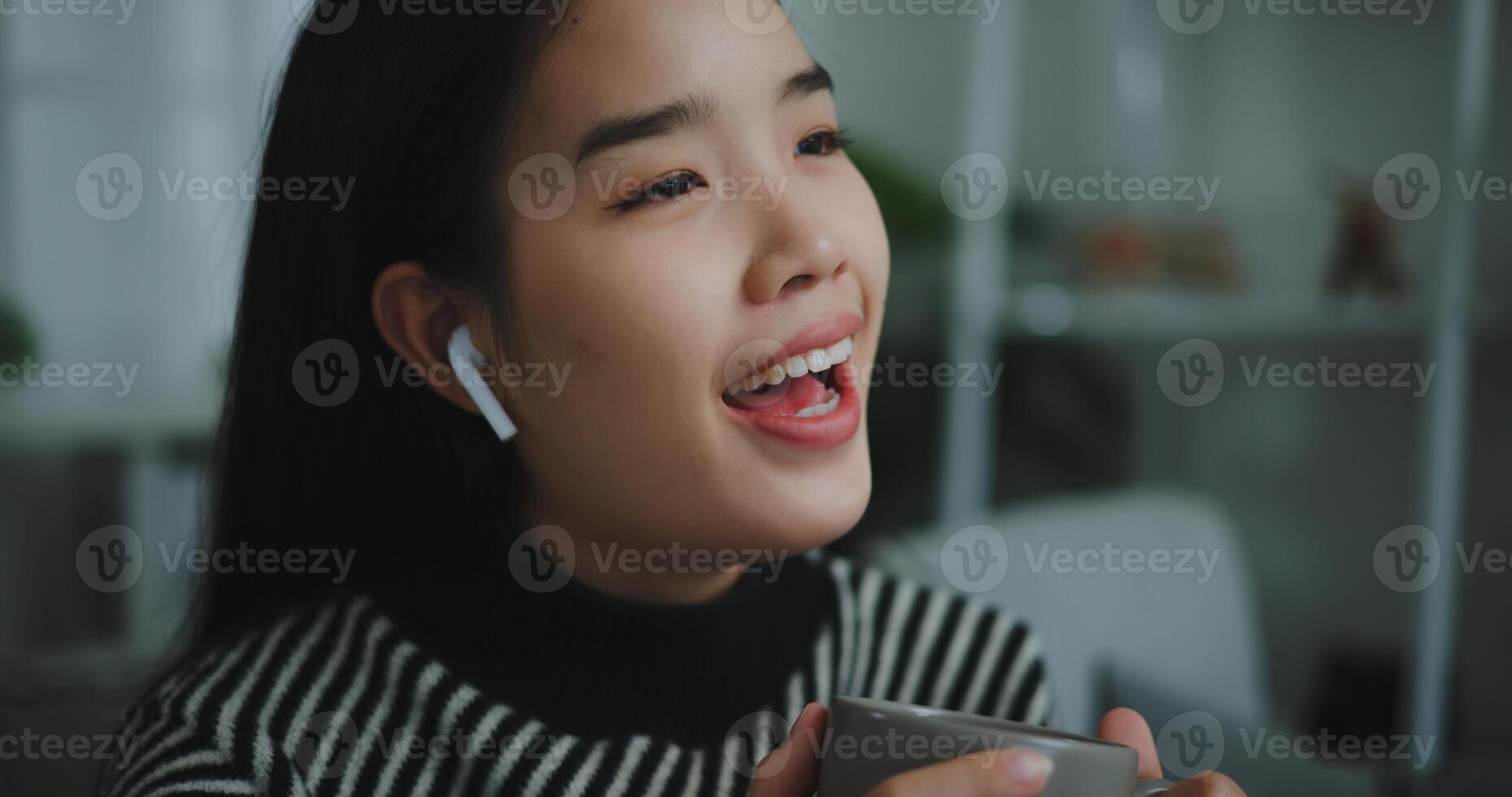 retrato de contento joven asiático mujer disfrutar escuchando a el música con inalámbrico auriculares mientras sentado bebida café en sofá en vivo habitación a hogar, ocio y estilo de vida, gratis hora foto