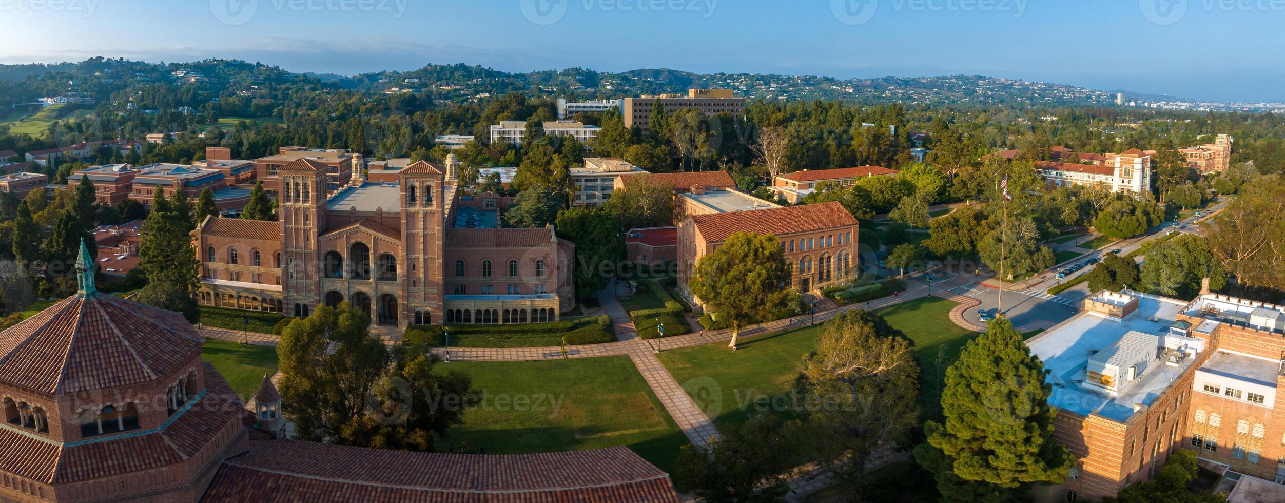 Aerial View of UCLA Campus with Gothic Tower, Red-Brick Buildings, and Lush Greenery at Sunset photo