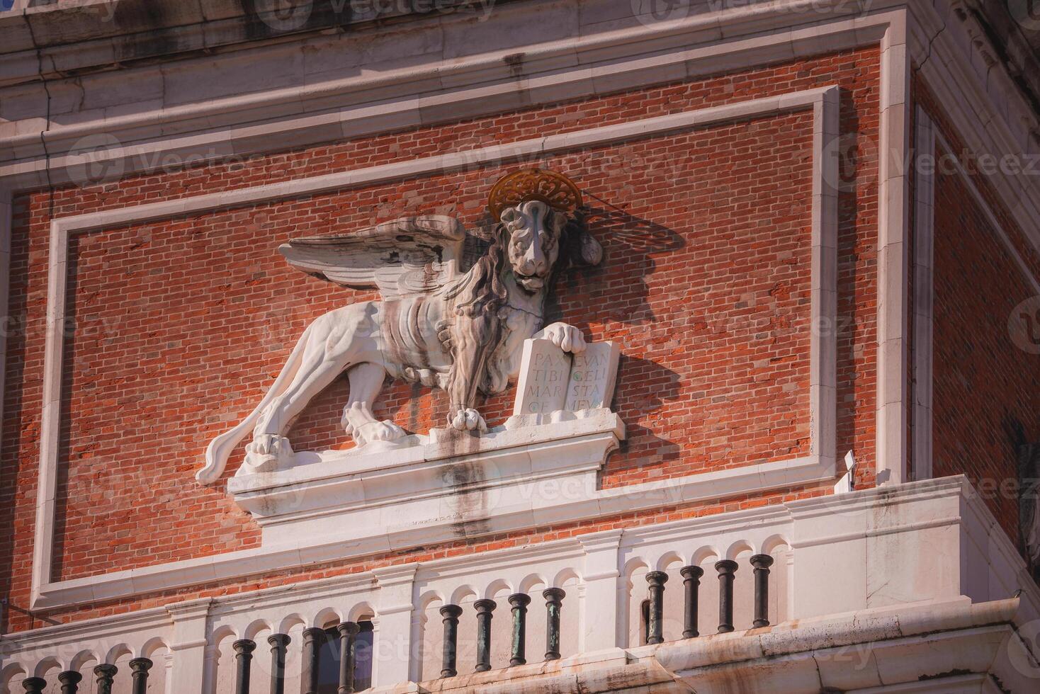 Majestic lion statue perched on building, overlooking city - historical significance unknown. photo