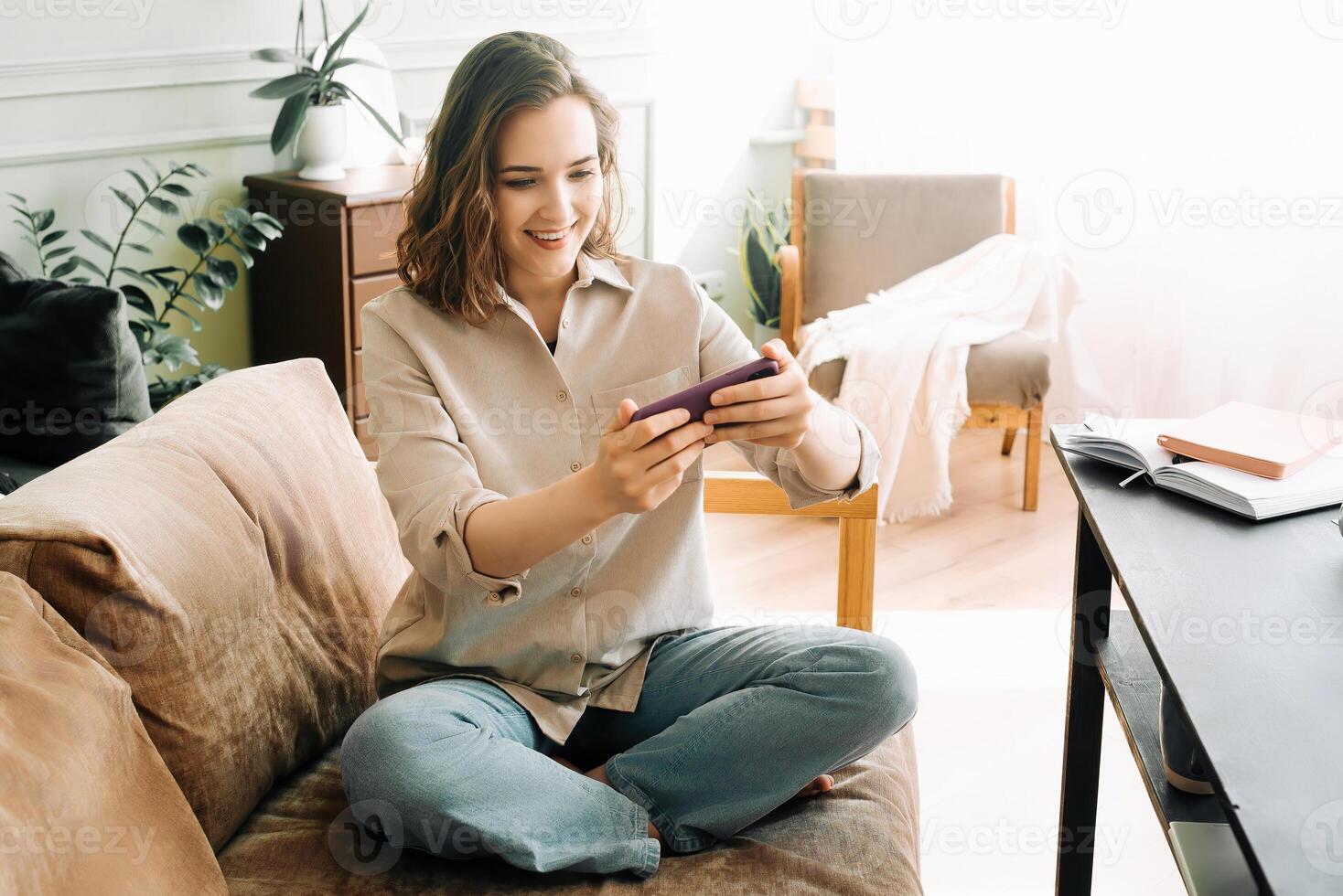 Woman Embracing Digital Connection. Reading Messages, Socializing on Social Media, and Playing Mobile Games on Smartphone. Happy Young Female Engaging in Modern Digital Communication and Entertainment photo