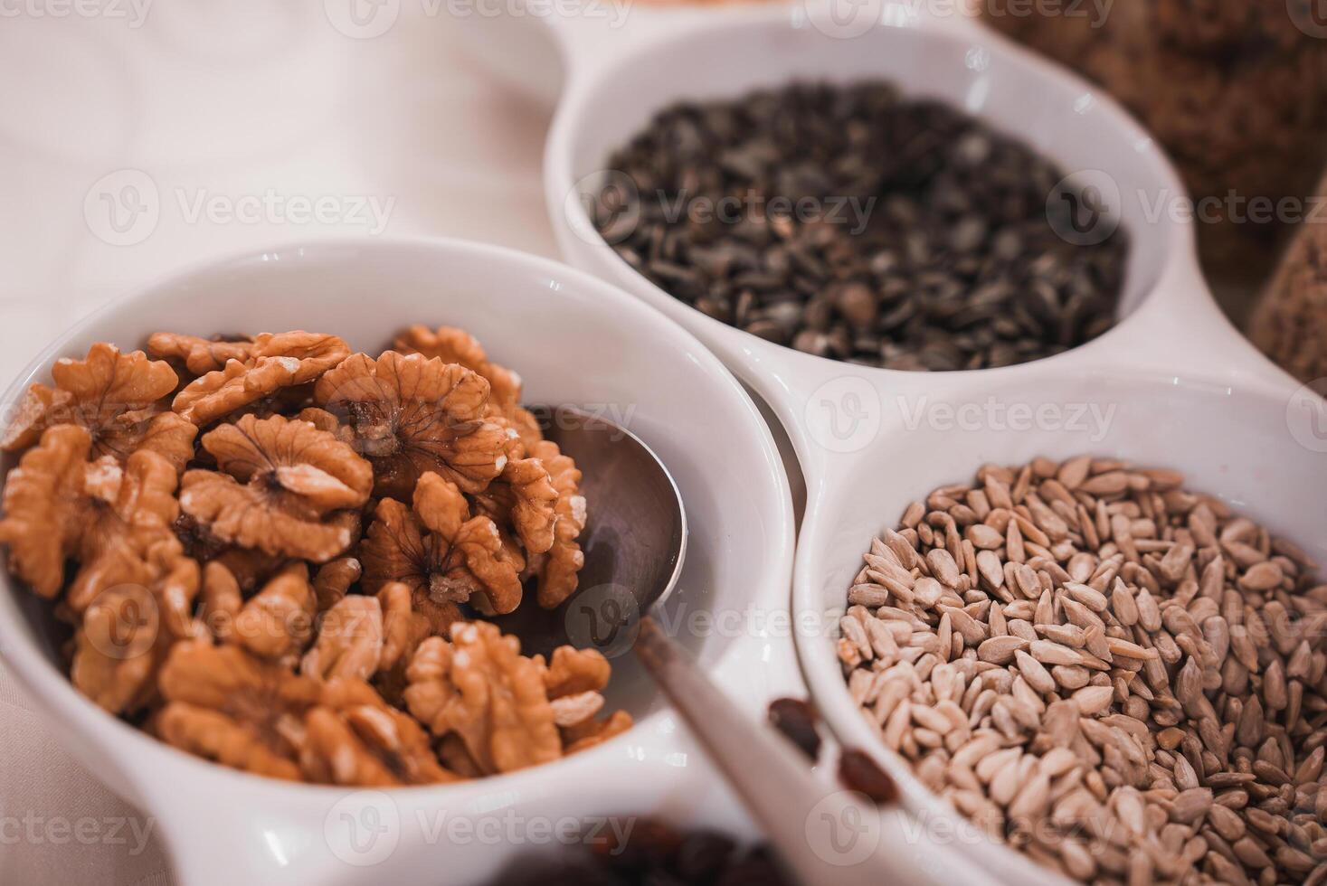 Assorted nuts and seeds in bowl on table in dim lighting, Venetian hotel interior. photo