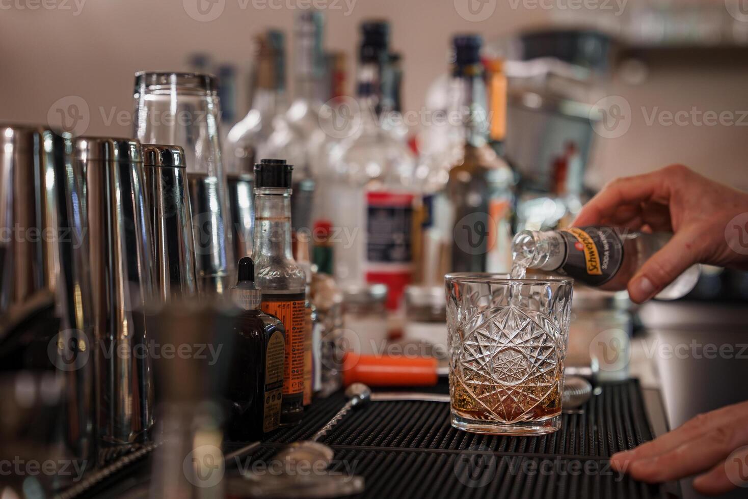 Professional bartender expertly pouring a delicious cocktail into a glass at a stylish bar. photo