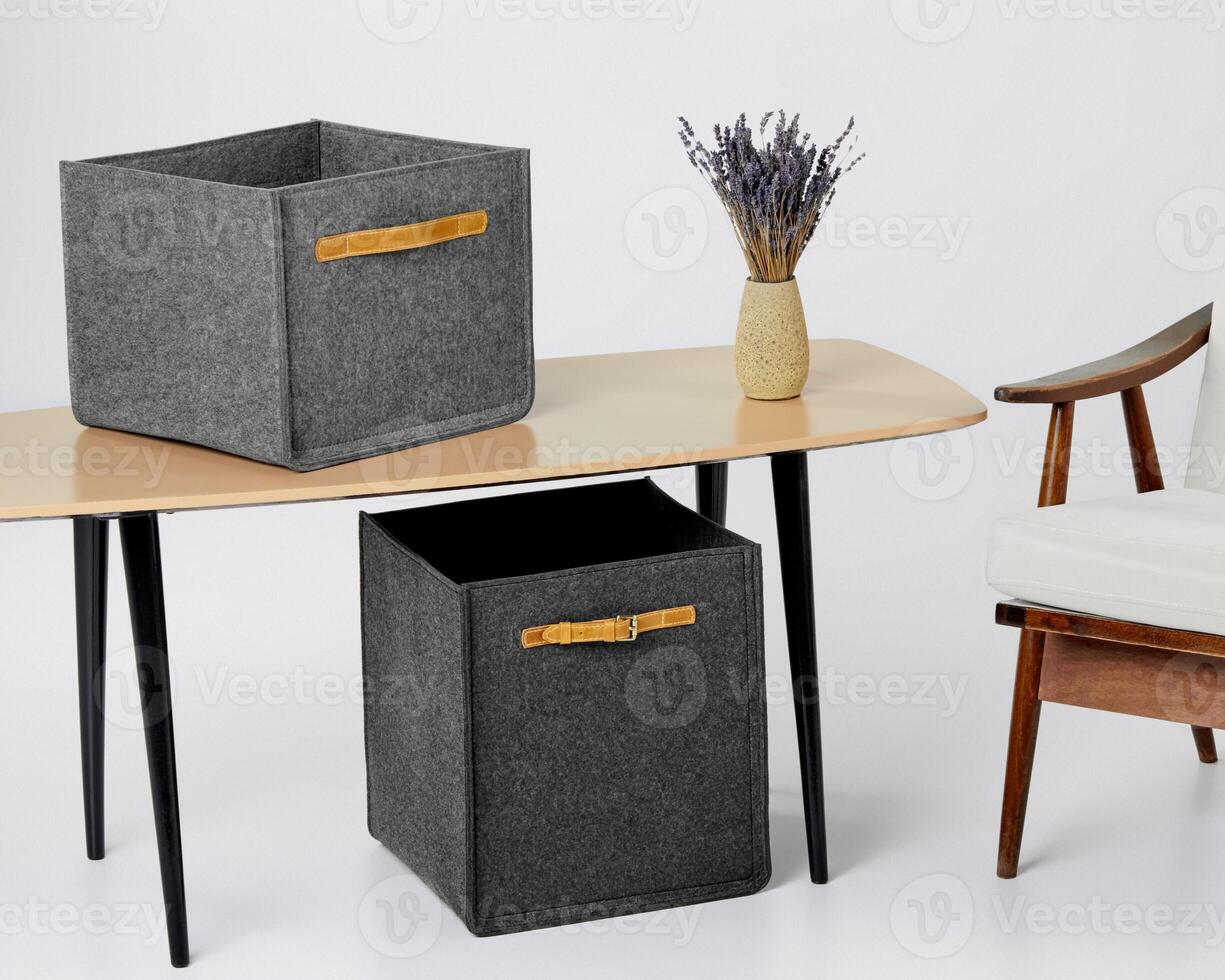 Two grey felt storage boxes and vase of lavender on desk photo