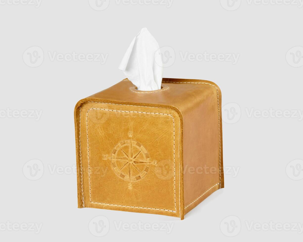 Tan leather tissue box cover with compass embossing on white photo