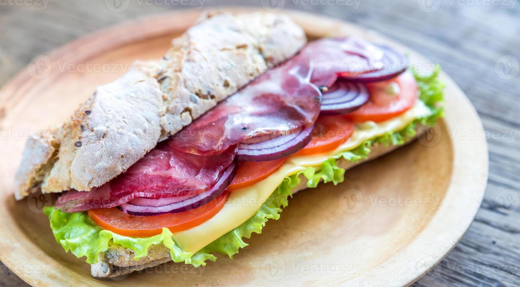 Sandwich with ham, cheese and fresh vegetables photo