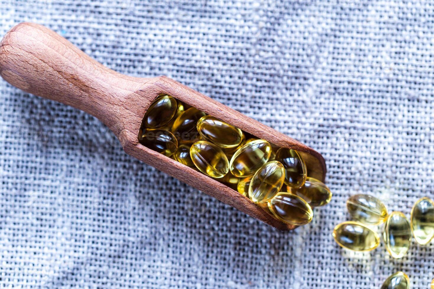 Omega-3 capsules in the wooden scoop photo