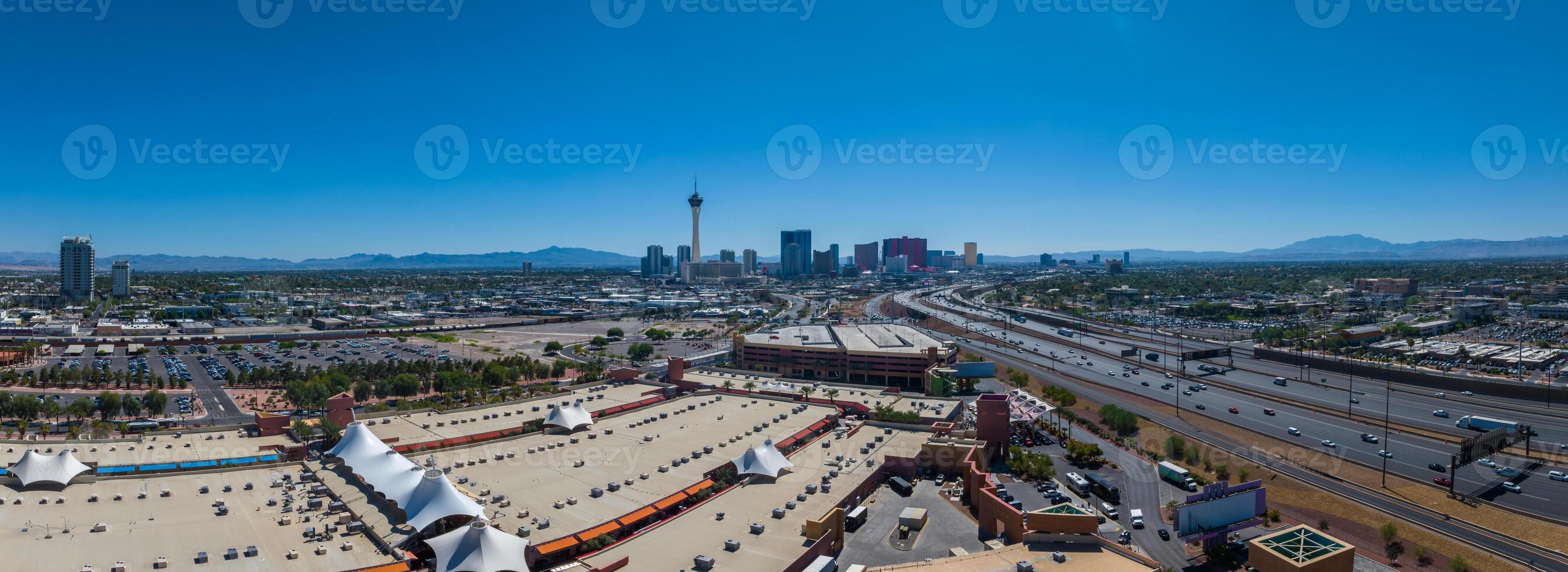 Panoramic Las Vegas Cityscape with Stratosphere Tower and Shopping Mall Amidst Mountains photo