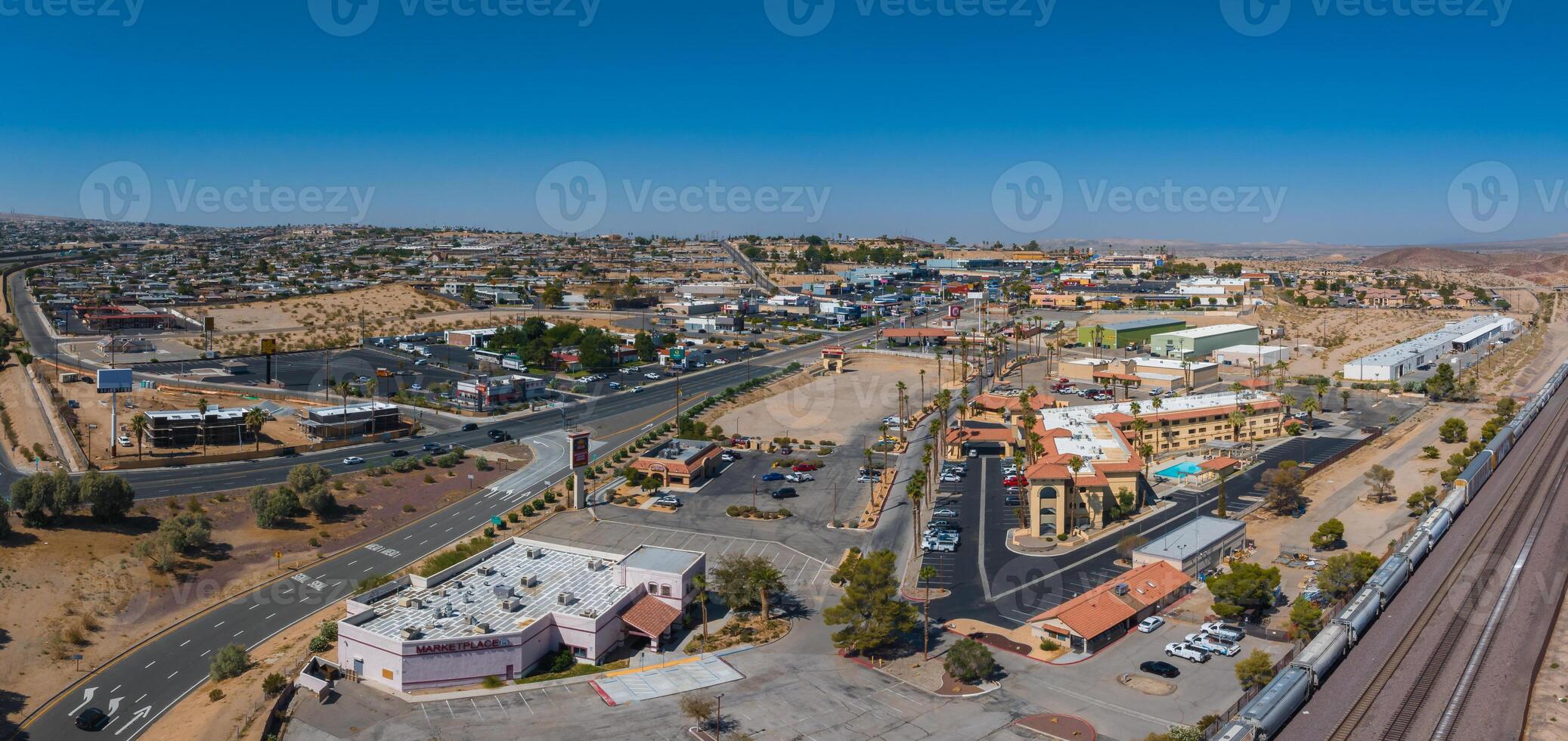 aéreo ver de Bartow americano pueblo con terroso tonos, tejas rojas techos, y Semi árido paisaje foto