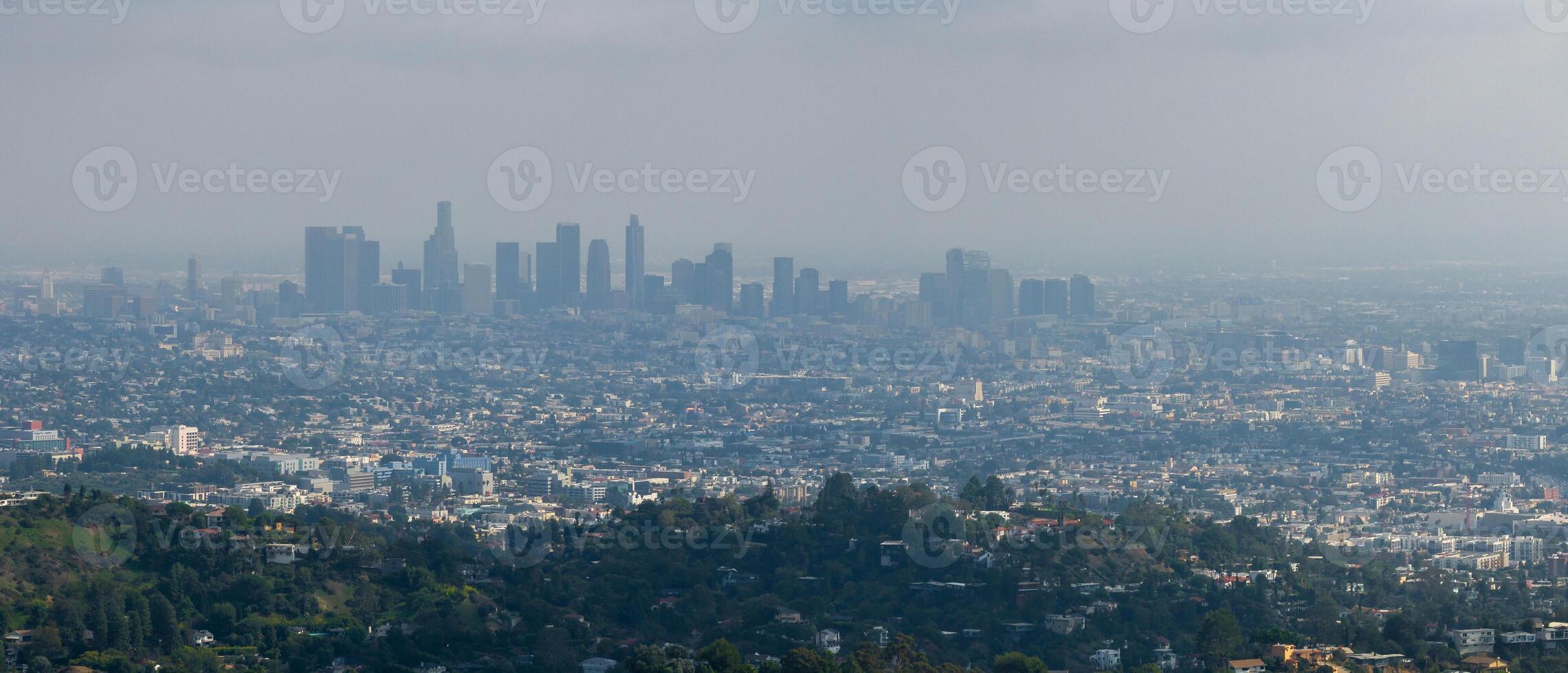 vista de la puesta de sol caliente de los angeles con palmeras y el centro de la ciudad en el fondo. foto