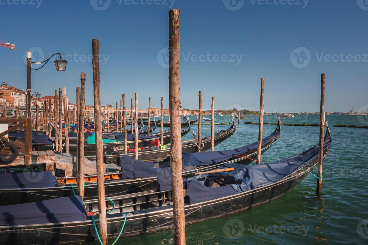 Tranquil Venice Gondolas Docked in Serene Water with Traditional Architecture in the Background photo