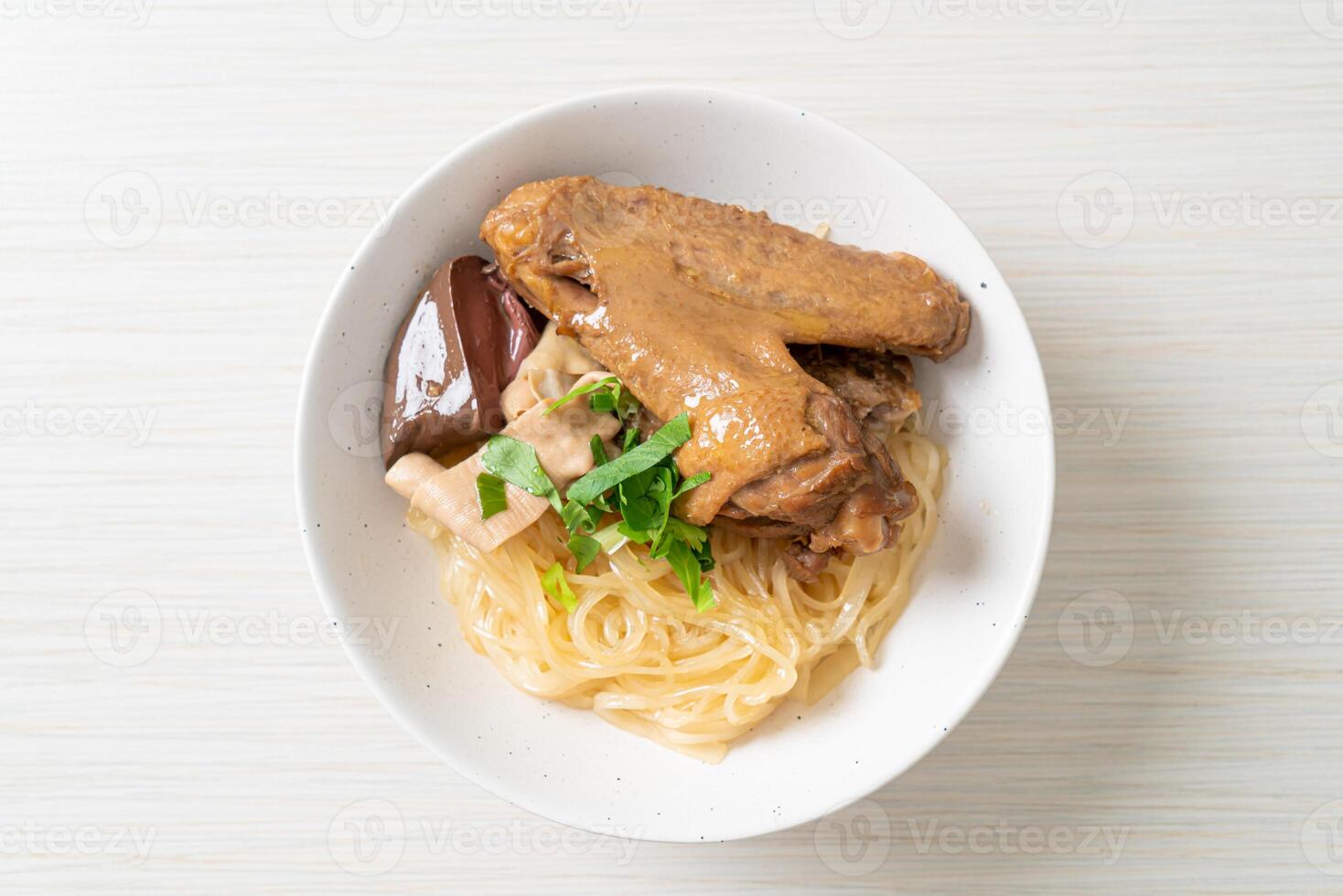 dried noodles with braised duck in white bowl photo