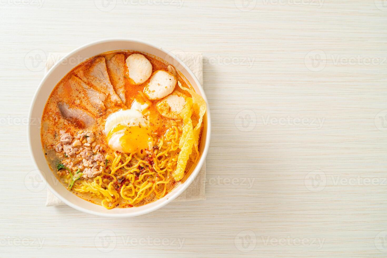 egg noodles with pork and meatball in spicy soup photo