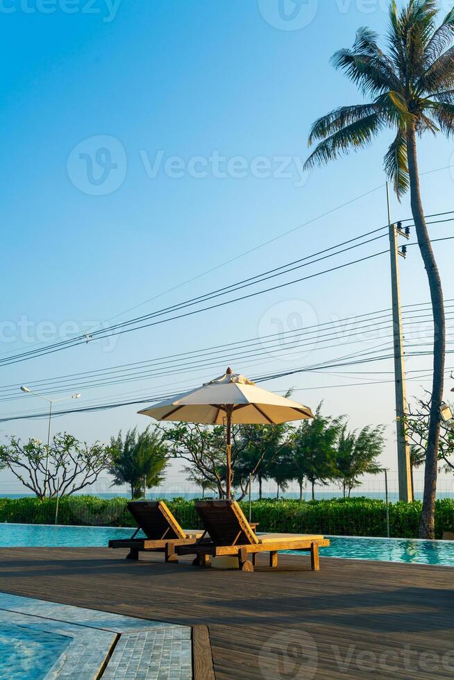 umbrella with bed pool around swimming pool with ocean sea background photo