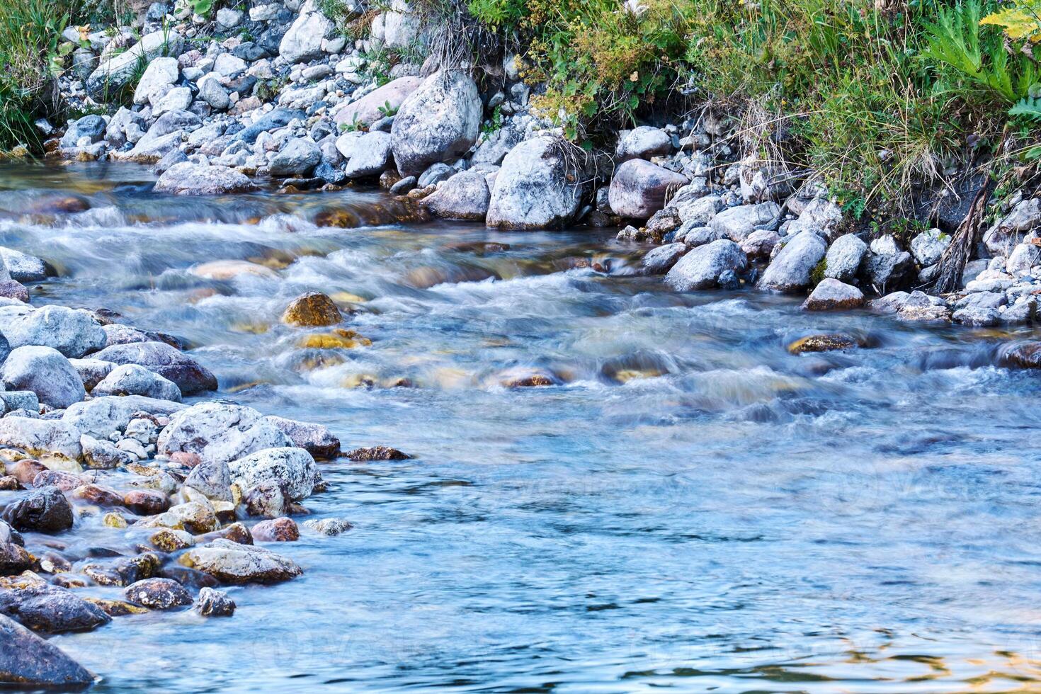 clean mountain stream in rocky shores blurred in motion photo