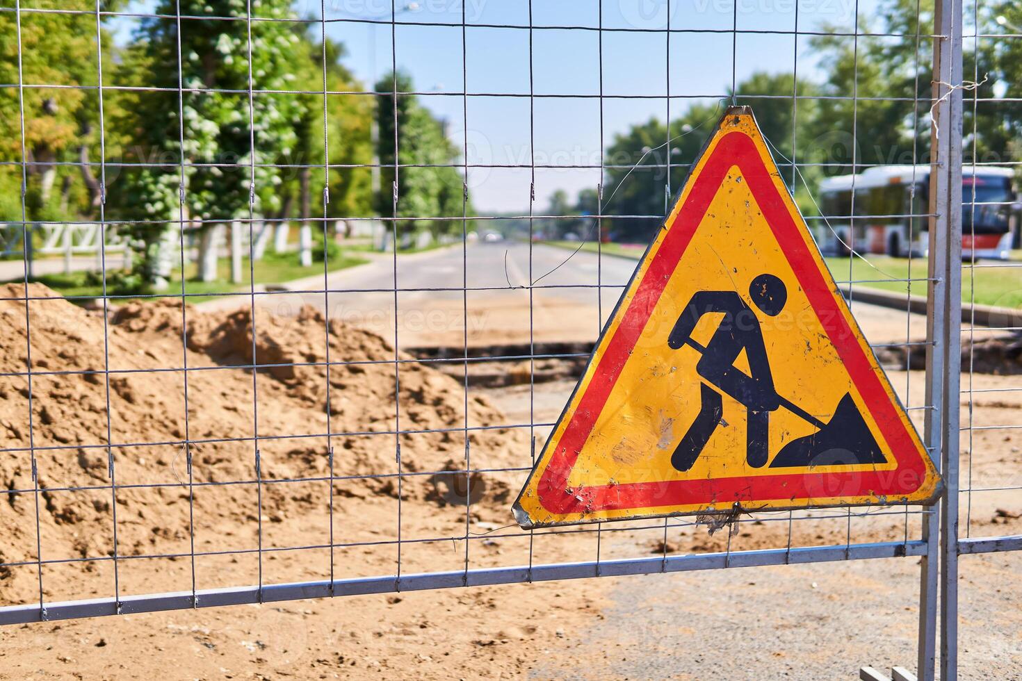 road sign Roadworks ahead on the fence against the background of a blurred dug street photo