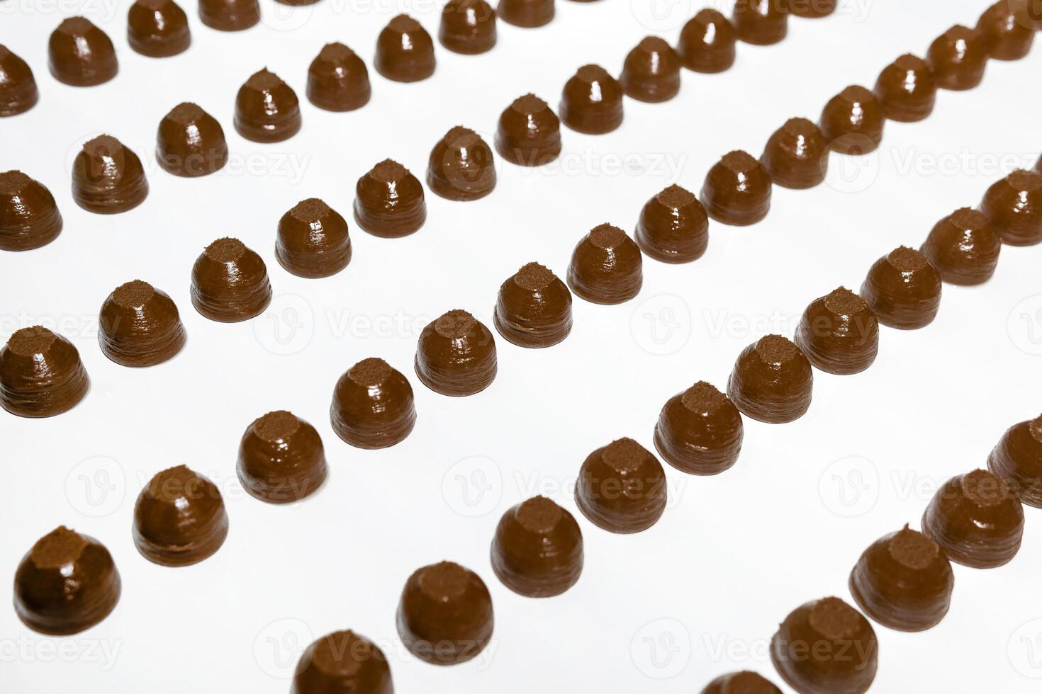 chocolate toppings on the conveyor of a confectionery factory close-up photo