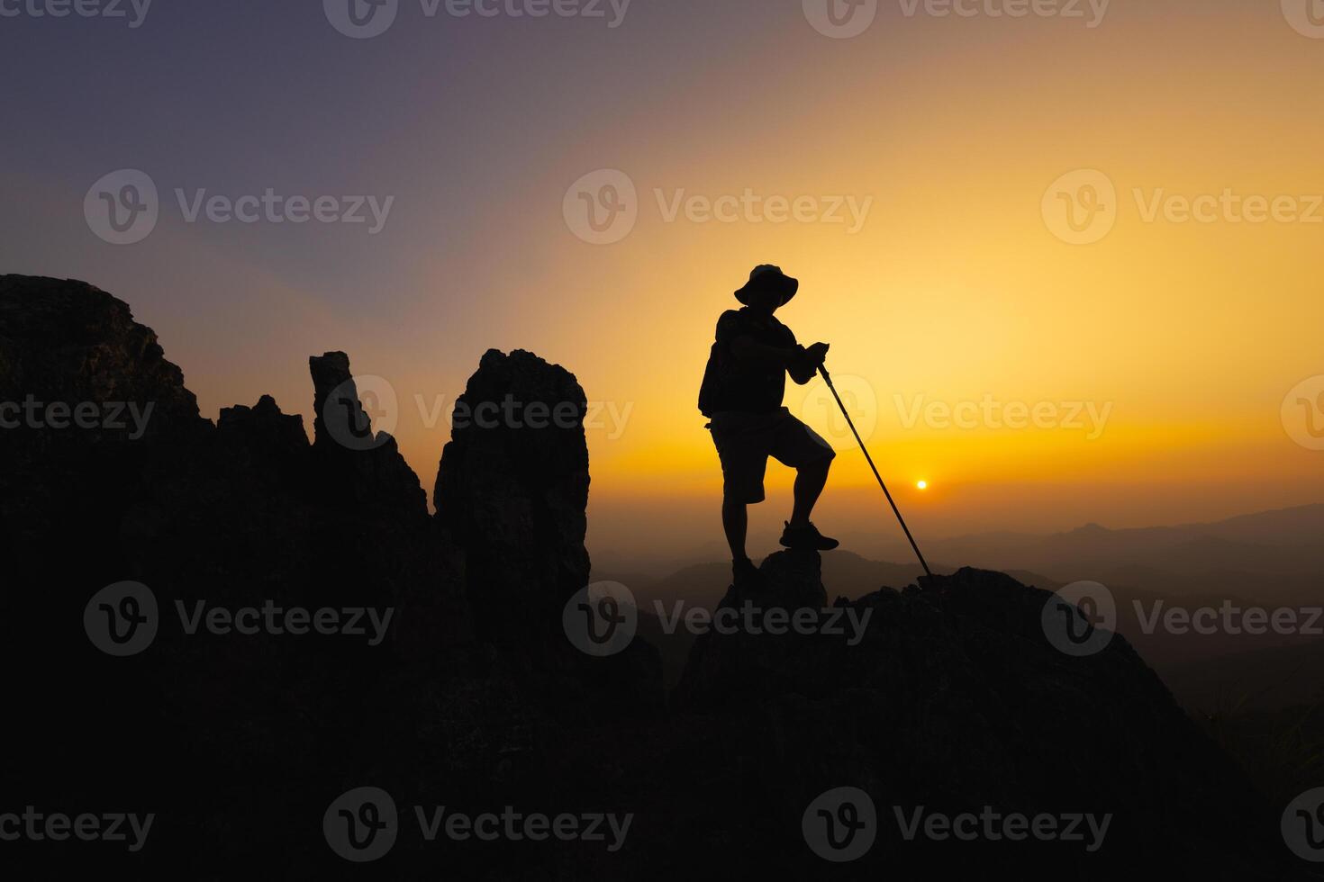 silueta de un trepador a el parte superior de el rocoso montaña a atardecer, hombre en parte superior de montaña. conceptual diseño. solo a el cumbre trepador exitoso escaladores deporte y activo vida. foto