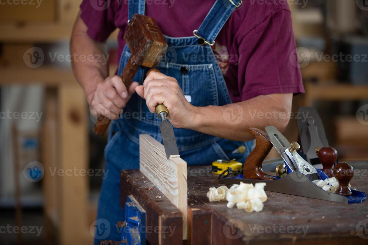 carpintero trabajando con equipo en de madera mesa. carpintero trabajando en carpintería máquinas en carpintería tienda. hombre trabajos en un carpintería tienda. foto