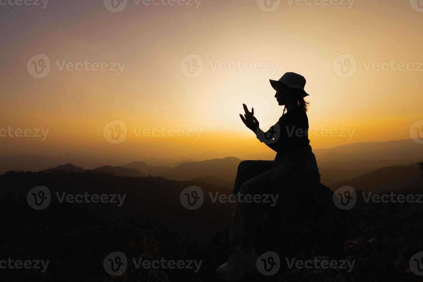 silueta de mujer cristiana rezando a mano, mujer rezando por la mañana en el fondo del amanecer. espiritualidad y religión, mujer rezando a dios. concepto de cristianismo. foto