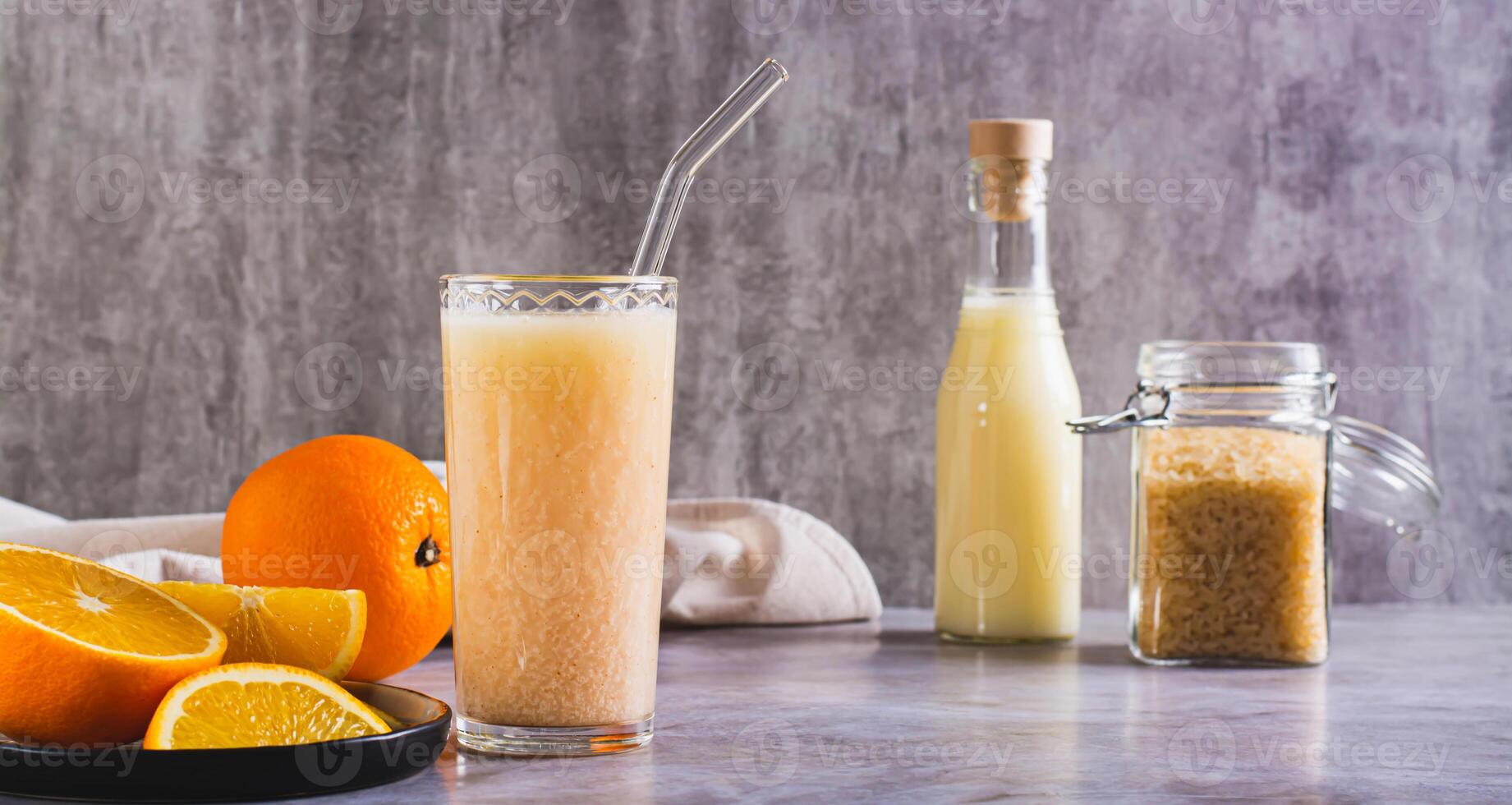 Vegetarian smoothie made from rice milk and orange in a glass on the table web banner photo