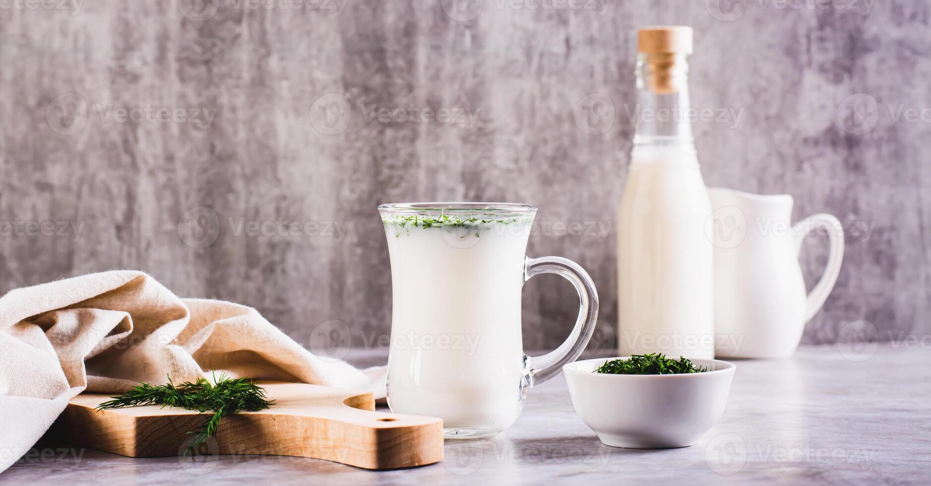 Ayran homemade yogurt drink with dill in a glass on the table web banner photo
