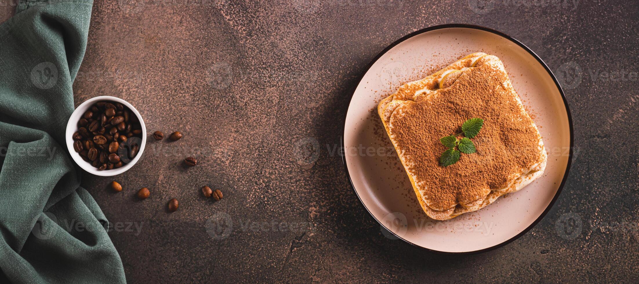 Tiramisu cake made of cookies, delicate cream and coffee on a plate top view web banner photo