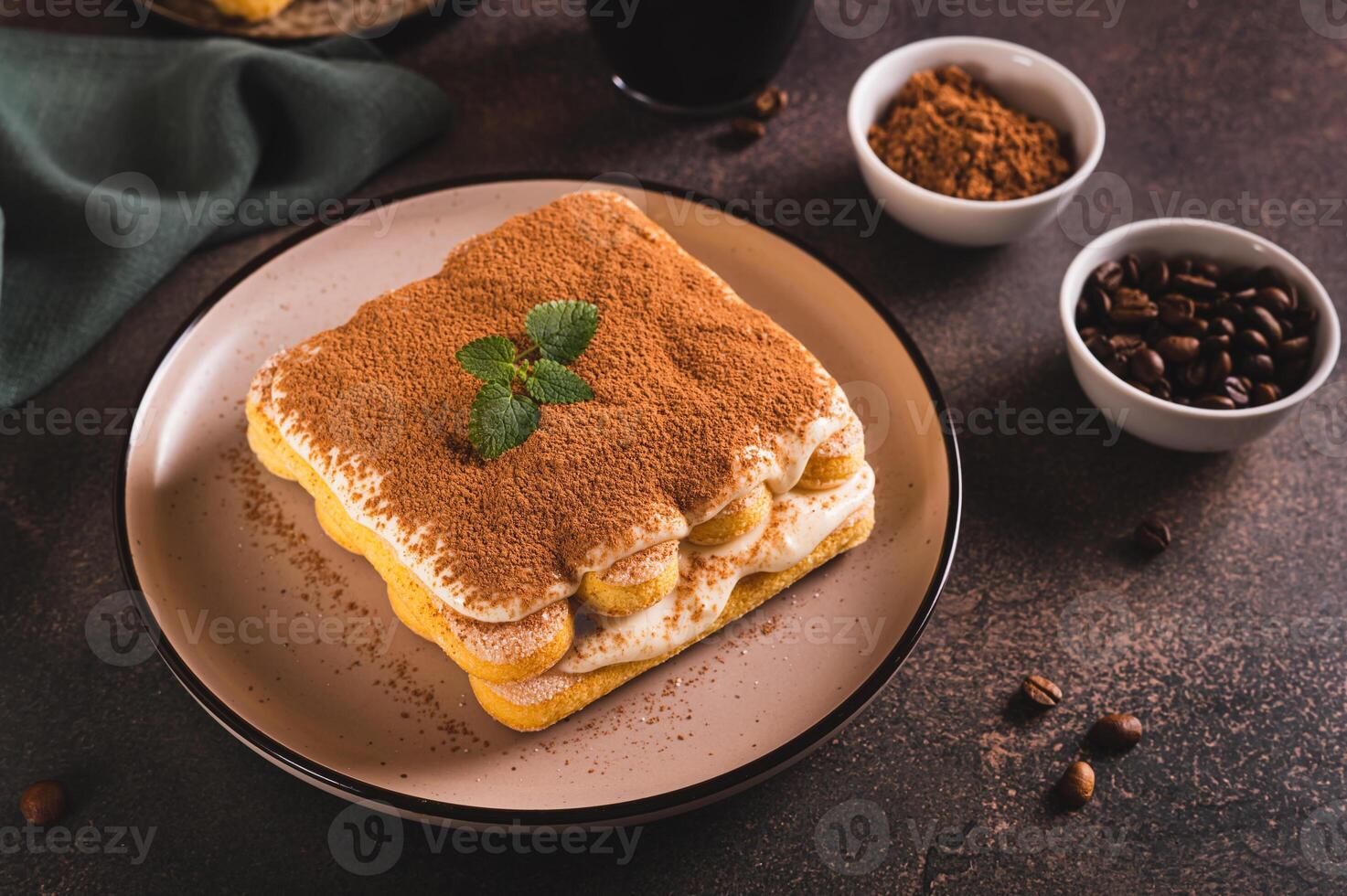 Tiramisu cake made of cookies, delicate cream and coffee on a plate on the table photo