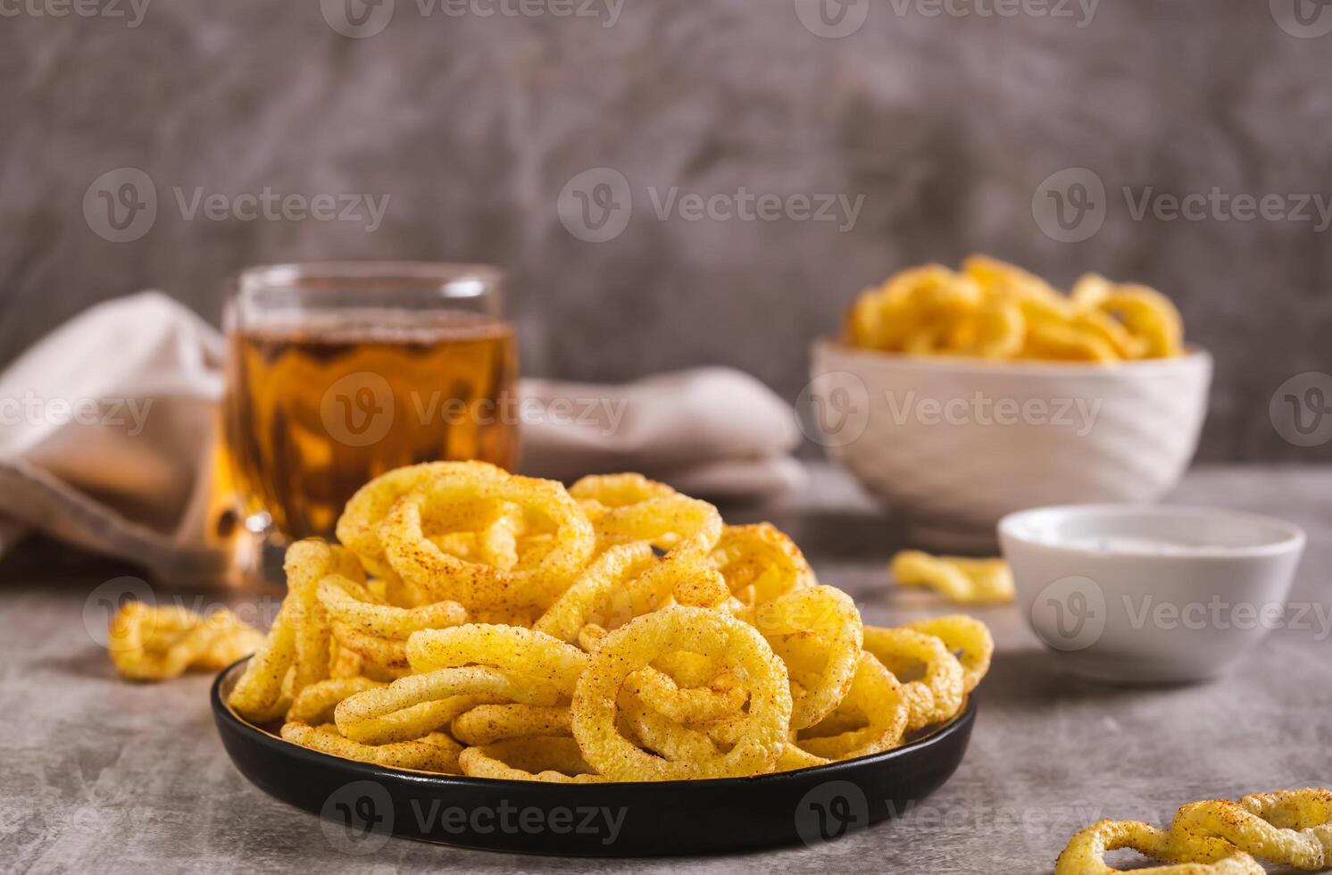 Onion rings, sauce and beer in a glass on the table photo