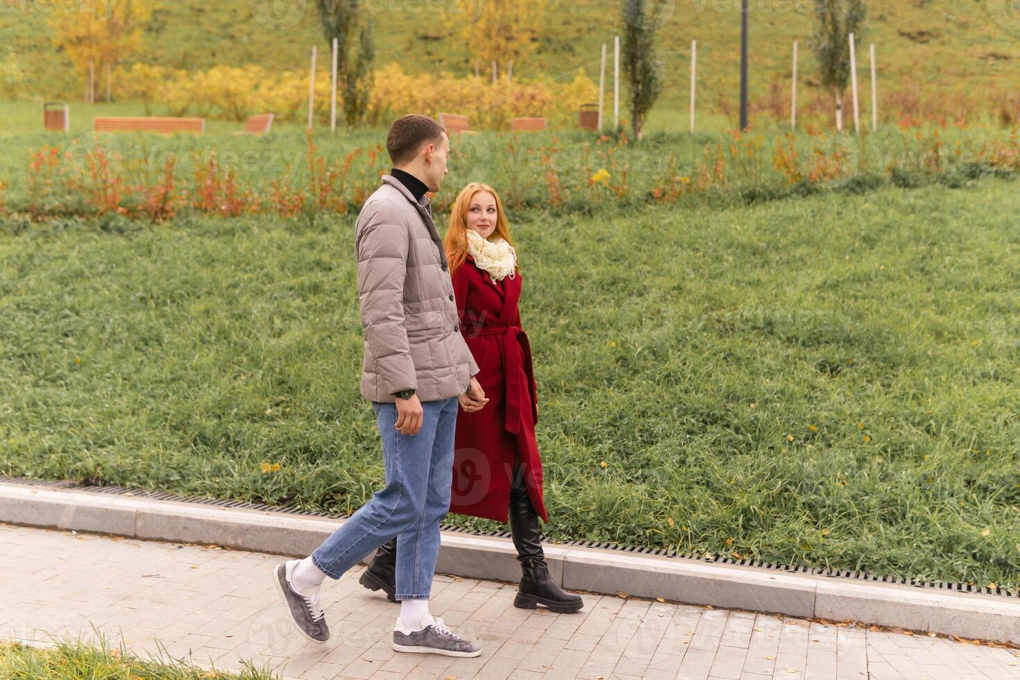 young couple walking in the autumn park photo