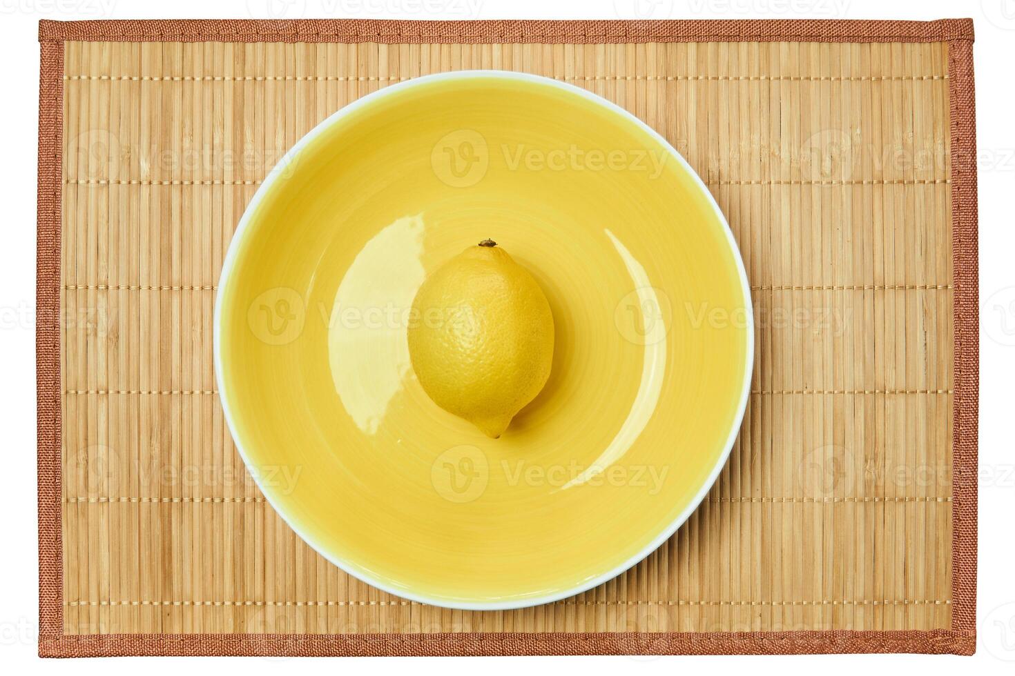 bright yellow lemon on a yellow plate on a cane place mat photo