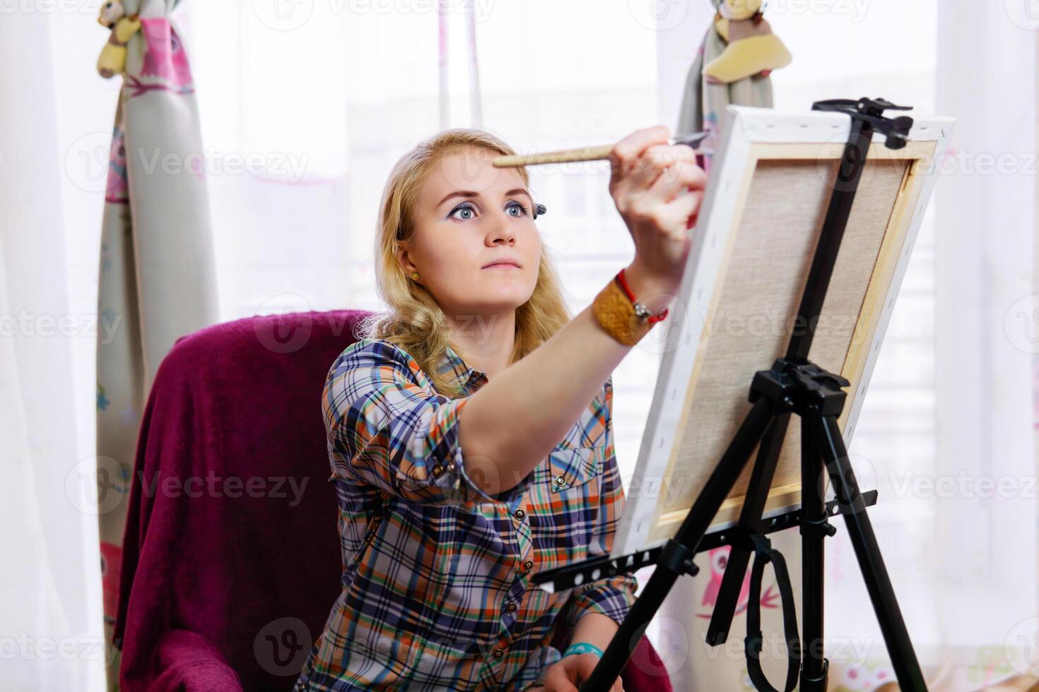 woman artist paints at an easel photo
