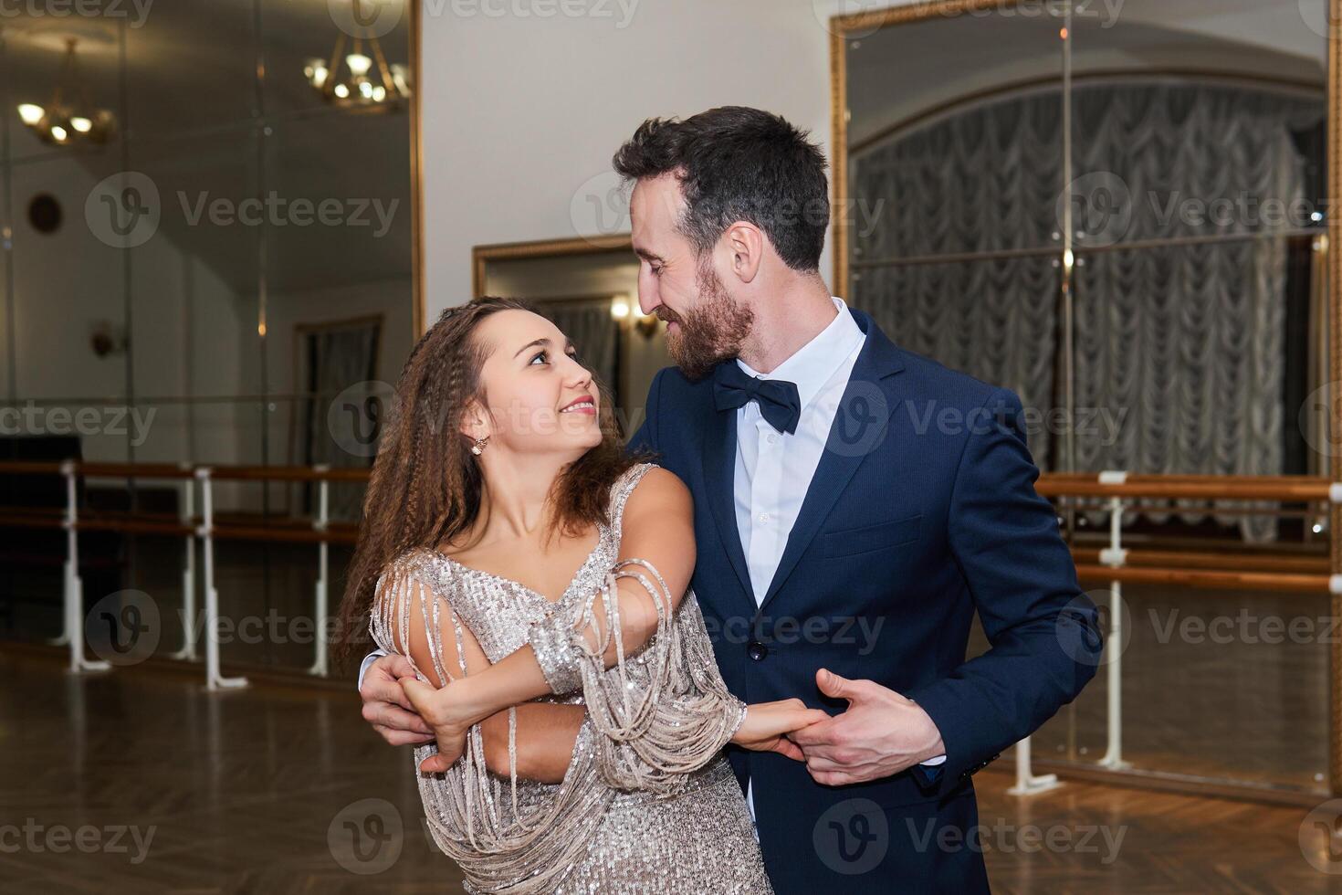 man and woman dance, looking at each other, in an empty ballroom photo