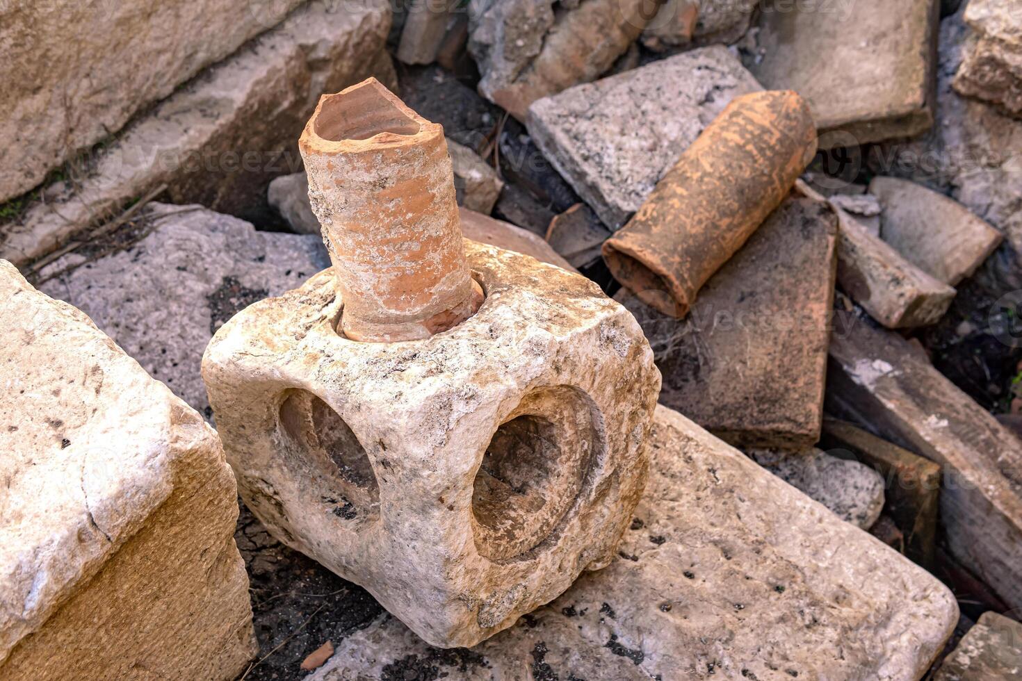 elements of the ancient roman plumbing among the ruins of an antique building photo