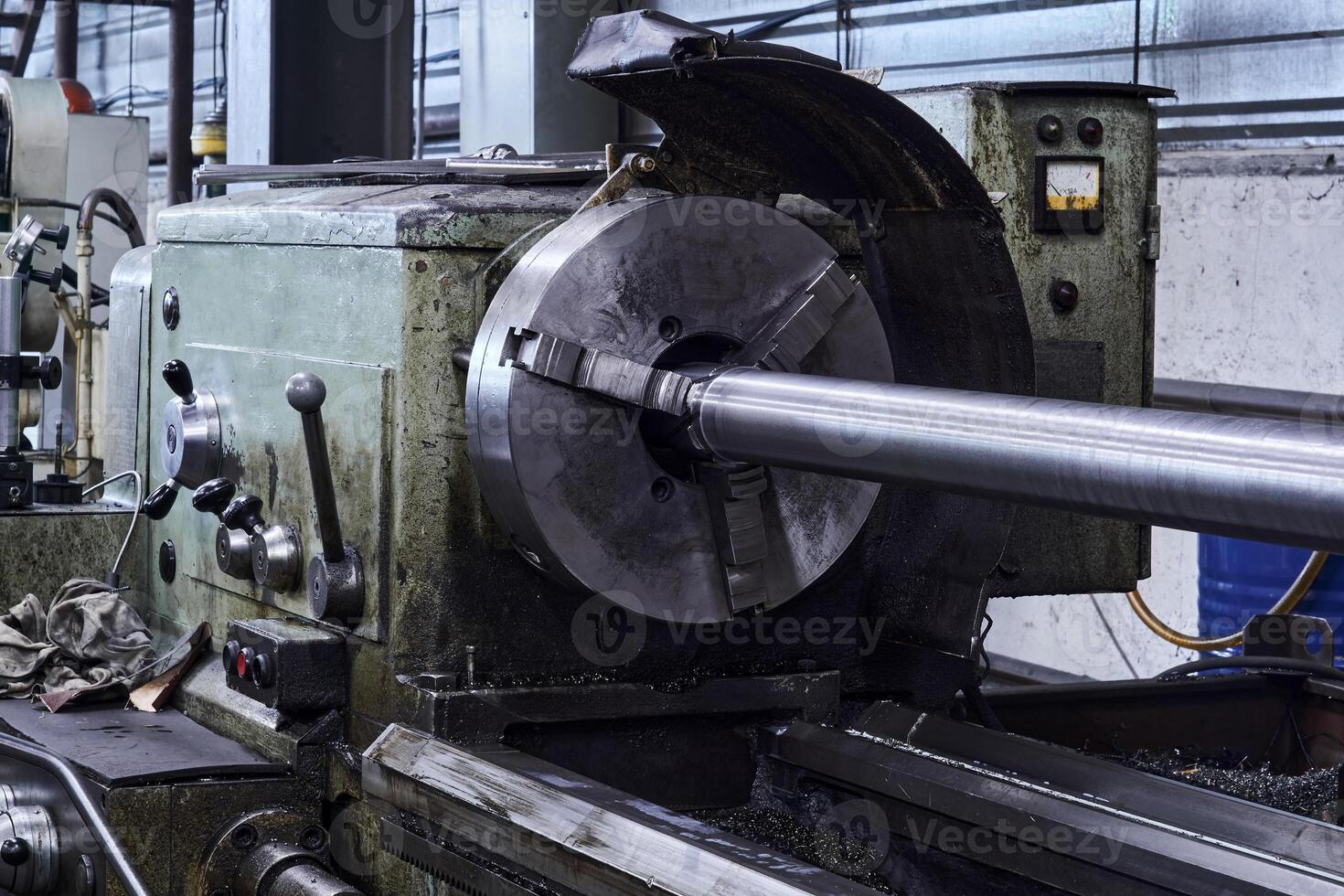lathe with a workpiece fixed in the spindle faceplate in the workshop photo