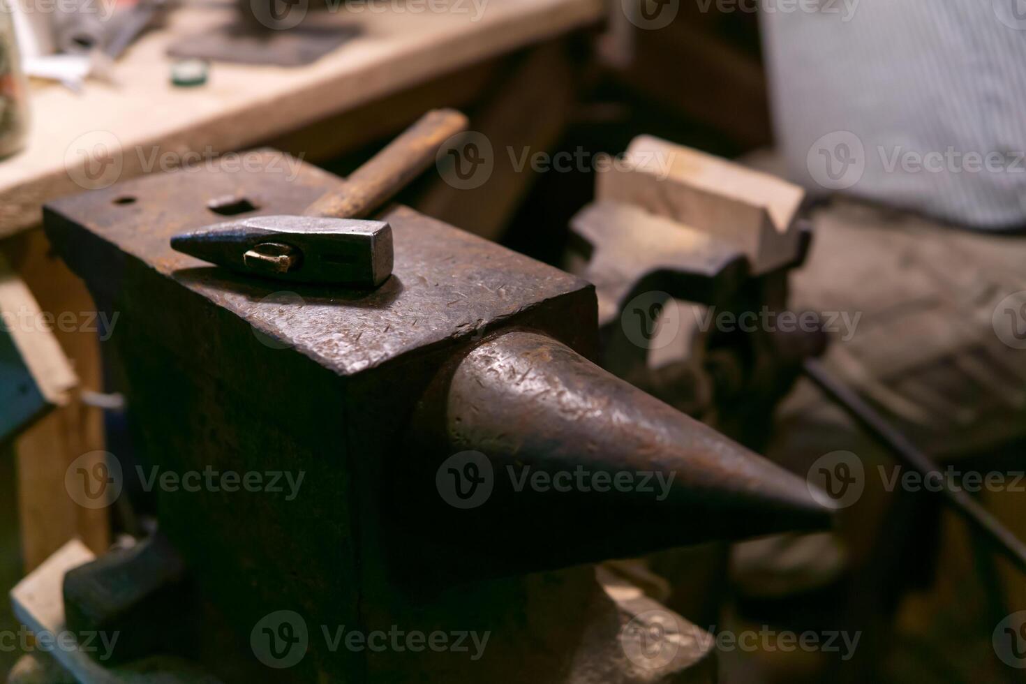 the hammer lies on the anvil in the workshop photo